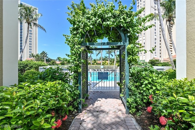 6549 Marissa Loop Unit 26, Naples, FL 34108 - view of gate featuring a community pool and fence