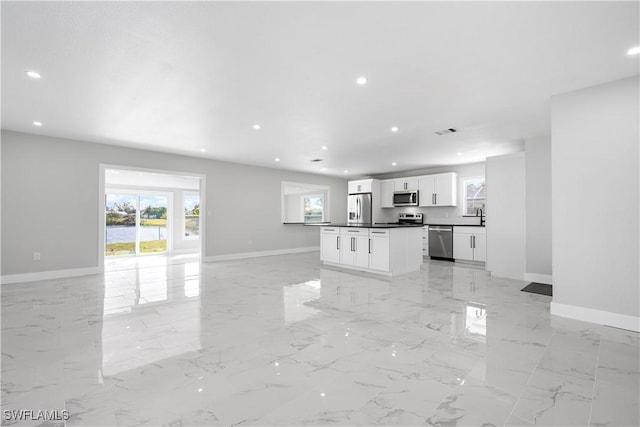 unfurnished living room featuring visible vents, a water view, baseboards, recessed lighting, and marble finish floor