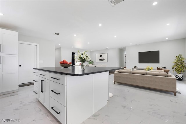 kitchen with dark countertops, recessed lighting, visible vents, and marble finish floor