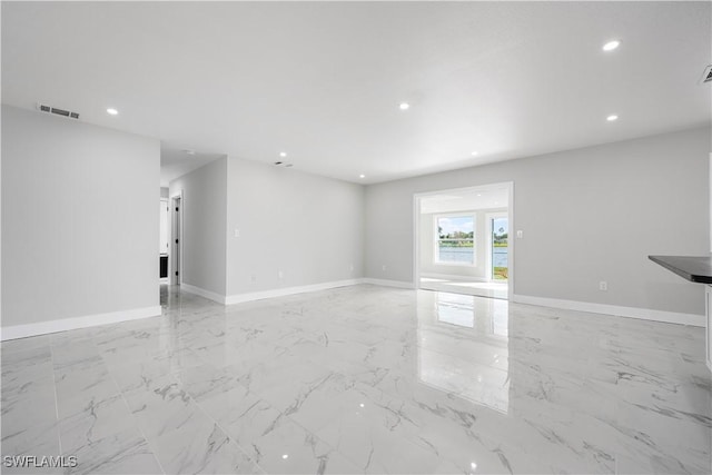unfurnished living room with visible vents, recessed lighting, baseboards, and marble finish floor