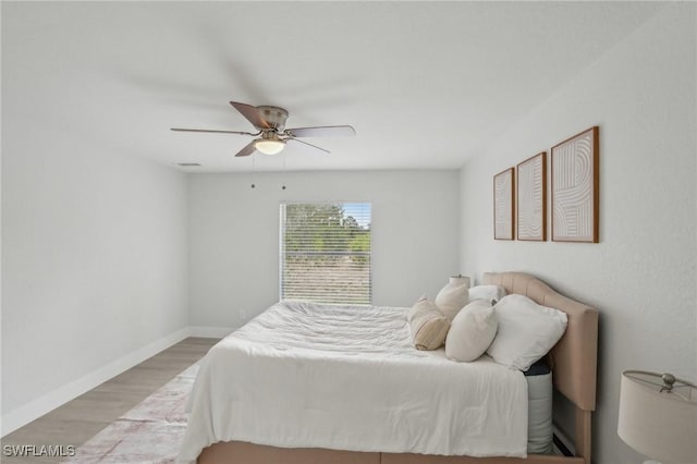bedroom featuring baseboards, ceiling fan, and wood finished floors