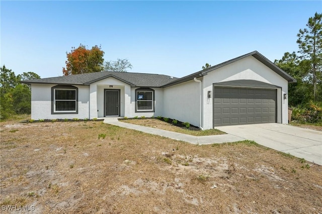 ranch-style home with a garage, stucco siding, and concrete driveway