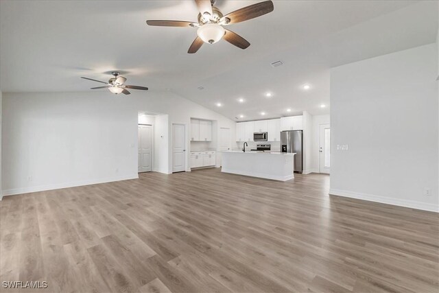 1904 NW 18th St, Cape Coral, FL 33993 - unfurnished living room with ceiling fan, vaulted ceiling, and light wood-style floors