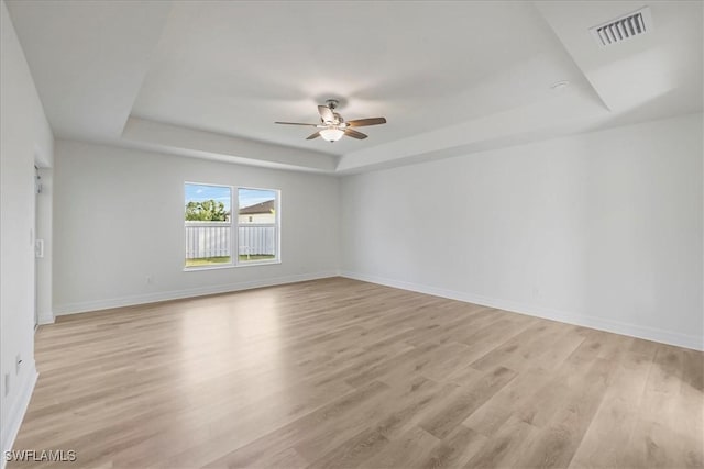1904 NW 18th St, Cape Coral, FL 33993 - empty room with a tray ceiling, visible vents, ceiling fan, and light wood-style flooring