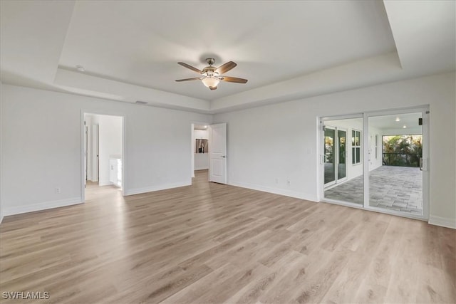 1904 NW 18th St, Cape Coral, FL 33993 - empty room featuring baseboards, a tray ceiling, ceiling fan, and light wood-style flooring