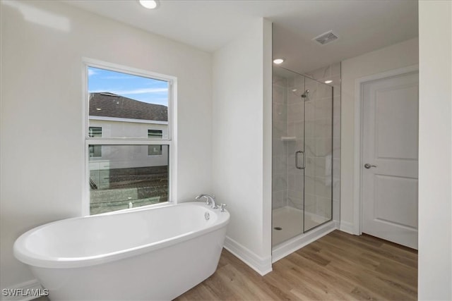 1904 NW 18th St, Cape Coral, FL 33993 - full bathroom featuring baseboards, a freestanding tub, wood finished floors, visible vents, and a stall shower