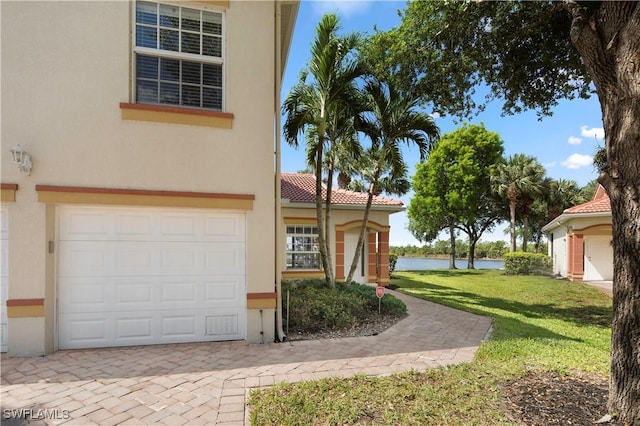 25073 Peacock Ln Unit 102, Naples, FL 34114 - mediterranean / spanish-style home with stucco siding, a front yard, and an attached garage