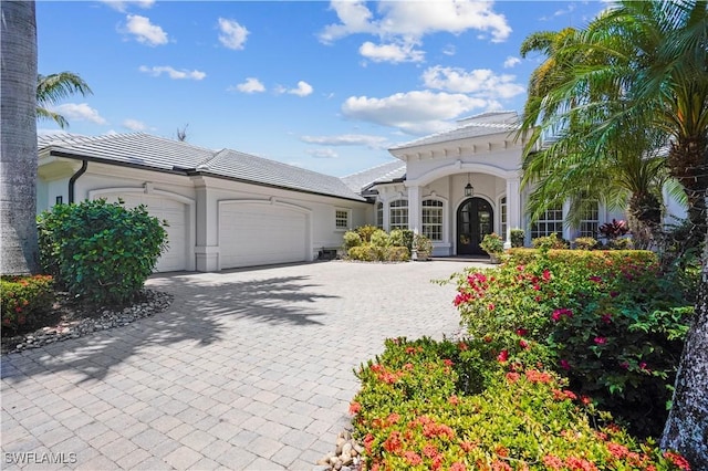10371 Via Anacapri Ct, Miromar Lakes, FL 33913 - mediterranean / spanish home with a tile roof, stucco siding, a garage, and decorative driveway