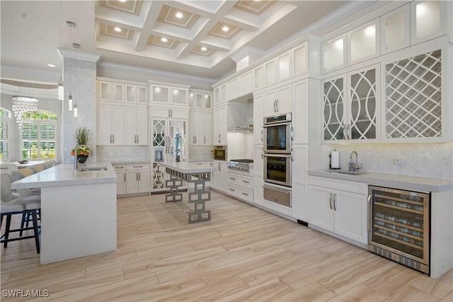 10371 Via Anacapri Ct, Miromar Lakes, FL 33913 - kitchen featuring a sink, a peninsula, stainless steel appliances, a warming drawer, and beverage cooler