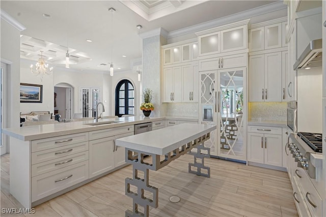 10371 Via Anacapri Ct, Miromar Lakes, FL 33913 - kitchen with a peninsula, coffered ceiling, crown molding, arched walkways, and appliances with stainless steel finishes
