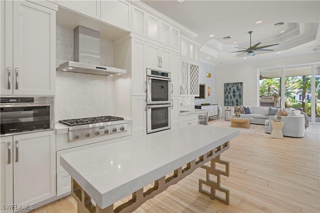 10371 Via Anacapri Ct, Miromar Lakes, FL 33913 - kitchen with stainless steel appliances, ceiling fan, wall chimney range hood, tasteful backsplash, and recessed lighting