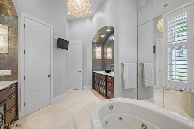 10371 Via Anacapri Ct, Miromar Lakes, FL 33913 - bathroom featuring baseboards, vanity, a chandelier, and a whirlpool tub