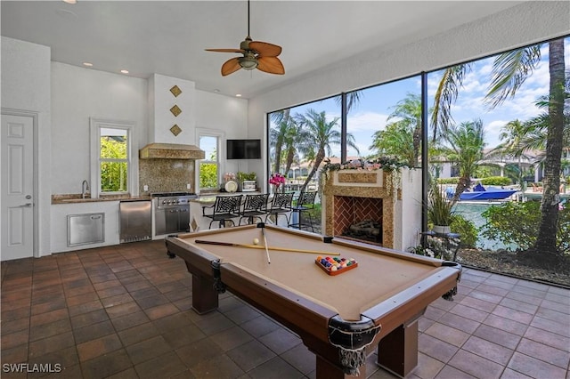 10371 Via Anacapri Ct, Miromar Lakes, FL 33913 - recreation room featuring a ceiling fan, a sink, dark tile patterned floors, a fireplace, and billiards