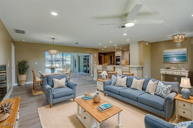living room with ceiling fan, light wood-style floors, recessed lighting, baseboards, and visible vents