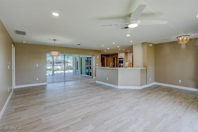 unfurnished living room with ceiling fan, visible vents, baseboards, recessed lighting, and light wood-style flooring