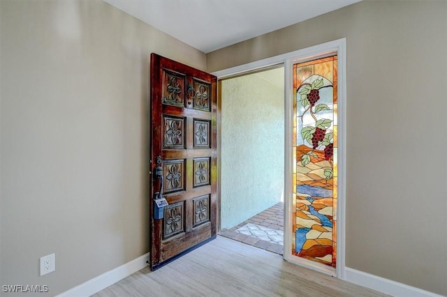 interior space featuring baseboards and light wood finished floors