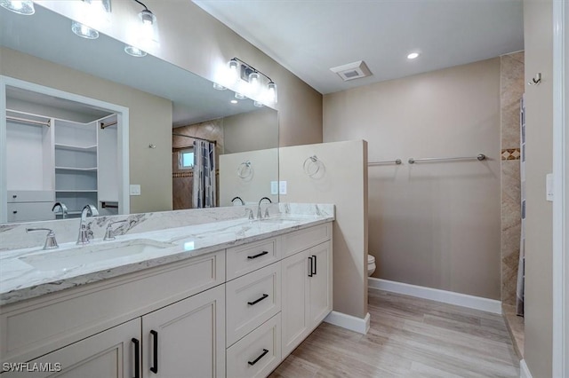 full bathroom featuring a sink, baseboards, wood finished floors, and visible vents