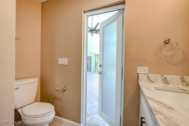 bathroom with toilet, baseboards, tile patterned flooring, and vanity