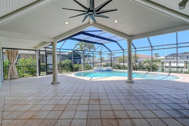 view of pool with ceiling fan, a pool with connected hot tub, a patio area, and glass enclosure