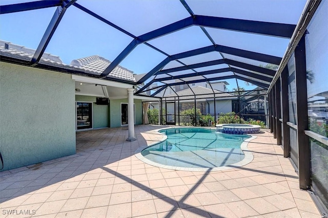 view of swimming pool featuring glass enclosure, a patio area, and a pool with connected hot tub