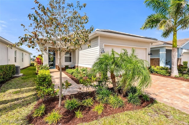 28306 Captiva Shell Loop, Bonita Springs, FL 34135 - view of front of house featuring decorative driveway, an attached garage, and cooling unit