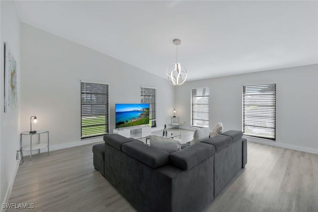 2723 SW 5th Ave, Cape Coral, FL 33914 - living area featuring light wood finished floors, baseboards, vaulted ceiling, and a chandelier