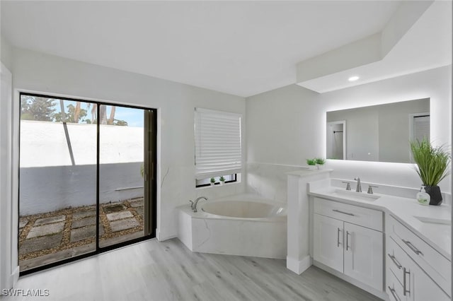 2723 SW 5th Ave, Cape Coral, FL 33914 - bathroom with vanity, a bath, recessed lighting, and wood finished floors