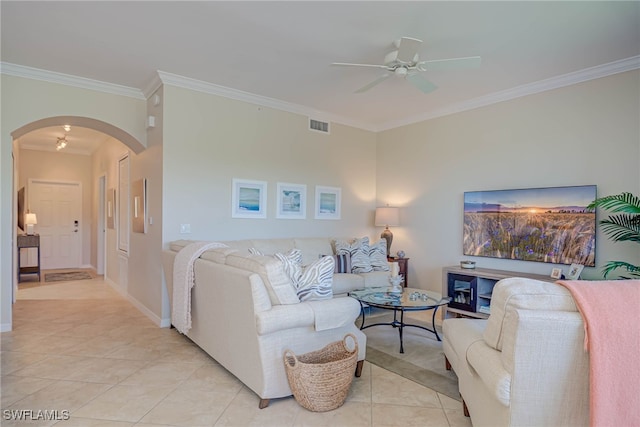 living area with crown molding, light tile patterned flooring, arched walkways, a ceiling fan, and visible vents