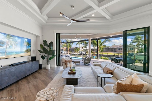 living area with ceiling fan, wood finished floors, a towering ceiling, beamed ceiling, and coffered ceiling