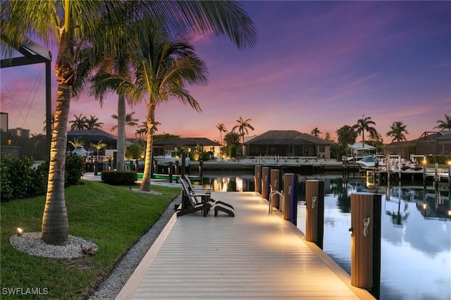 dock area featuring a lawn, a water view, and a residential view