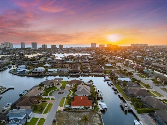 aerial view at dusk with a view of city and a water view