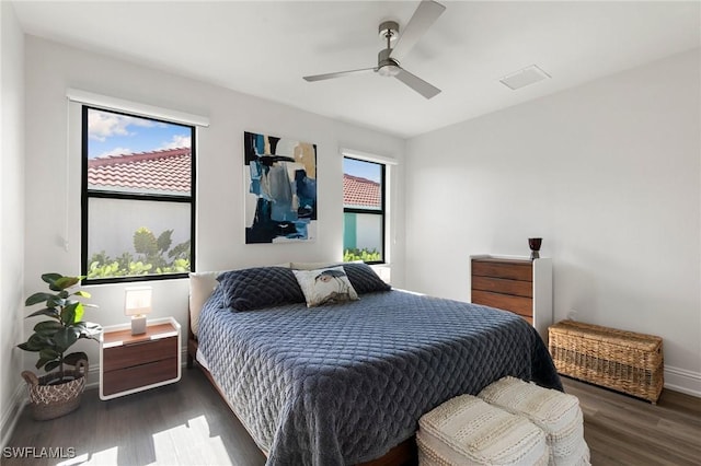 bedroom with baseboards, a ceiling fan, wood finished floors, and visible vents