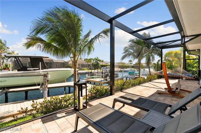 view of patio / terrace with glass enclosure, boat lift, a dock, and a water view