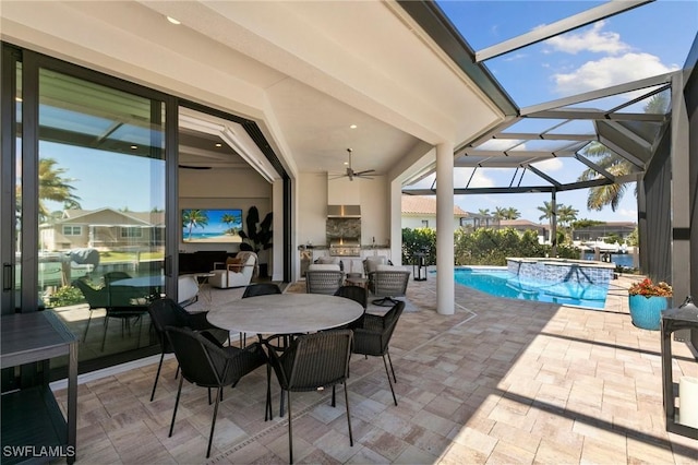view of patio / terrace with an outdoor kitchen, a ceiling fan, a lanai, and a pool with connected hot tub