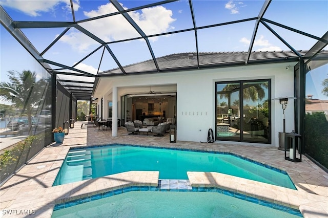 view of swimming pool featuring glass enclosure, a patio, a pool with connected hot tub, and outdoor lounge area