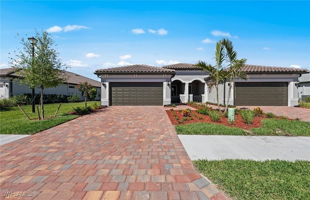 16748 Rolling Rock Blvd, Alva, FL 33920 - mediterranean / spanish home featuring a garage, decorative driveway, stucco siding, and a tiled roof