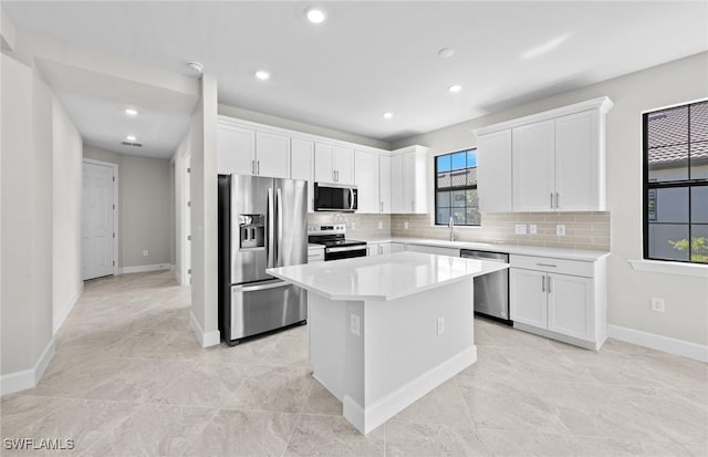 16748 Rolling Rock Blvd, Alva, FL 33920 - kitchen with appliances with stainless steel finishes, a kitchen island, white cabinets, tasteful backsplash, and recessed lighting