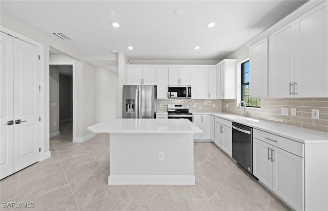 16748 Rolling Rock Blvd, Alva, FL 33920 - kitchen featuring appliances with stainless steel finishes, a sink, backsplash, a center island, and white cabinetry