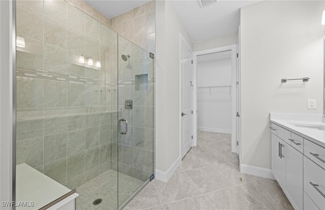 16748 Rolling Rock Blvd, Alva, FL 33920 - bathroom with a stall shower, baseboards, a walk in closet, vanity, and tile patterned flooring