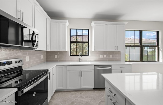 16748 Rolling Rock Blvd, Alva, FL 33920 - kitchen featuring stainless steel appliances, a sink, decorative backsplash, and white cabinets