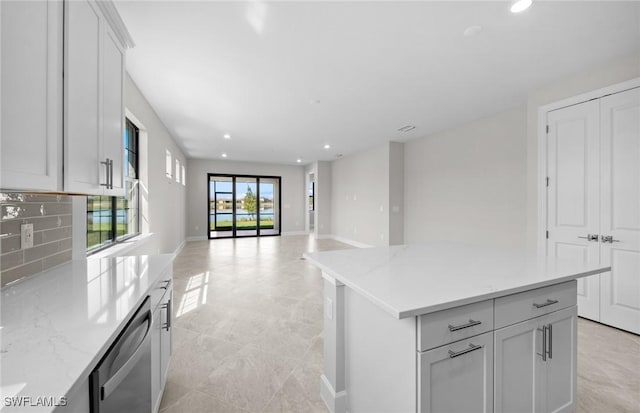 16748 Rolling Rock Blvd, Alva, FL 33920 - kitchen with recessed lighting, decorative backsplash, a kitchen island, white cabinetry, and baseboards