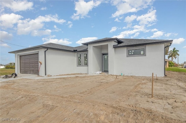 prairie-style home featuring a garage and stucco siding
