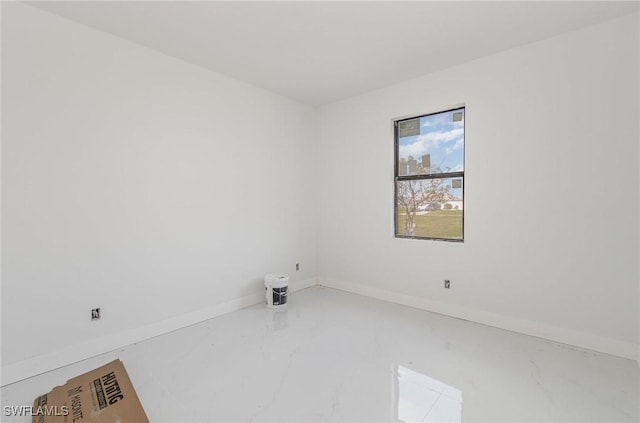 unfurnished room with baseboards and marble finish floor