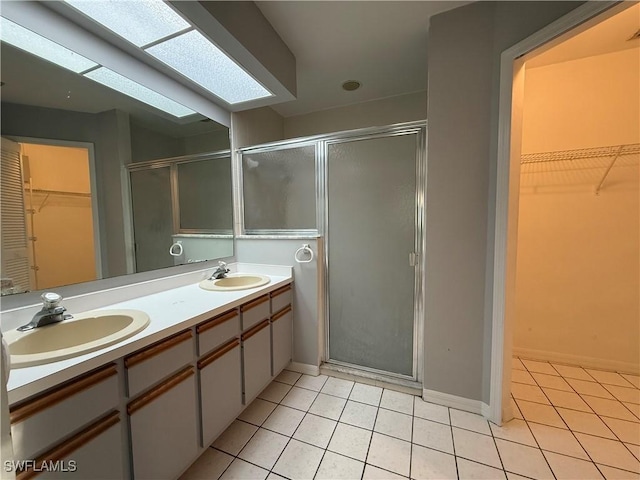 bathroom featuring a shower stall, a sink, and tile patterned flooring