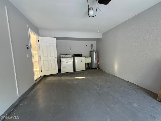 garage featuring water heater, independent washer and dryer, and a sink