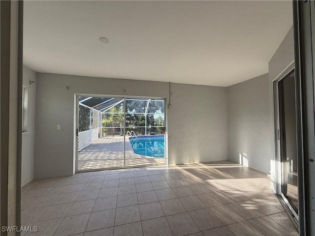 spare room with a sunroom, tile patterned floors, and a textured wall
