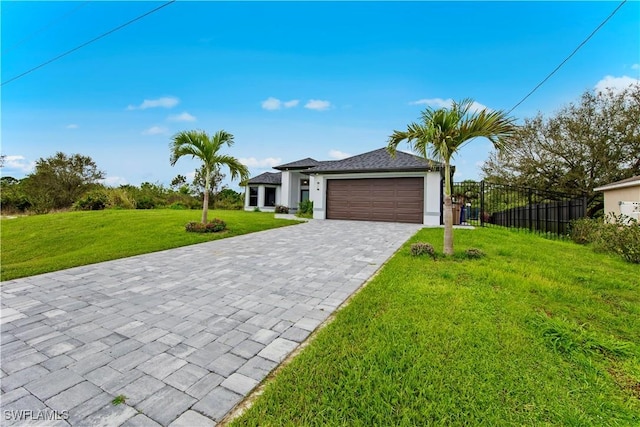 view of front of home featuring fence, a front yard, decorative driveway, stucco siding, and an attached garage