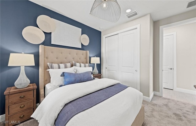 carpeted bedroom with baseboards, visible vents, and a closet