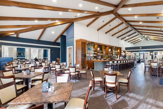 dining space with high vaulted ceiling, beam ceiling, recessed lighting, and wood finished floors