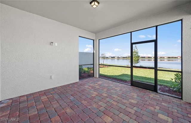16740 Rolling Rock Blvd, Alva, FL 33920 - unfurnished sunroom with a water view, a textured wall, and brick flooring